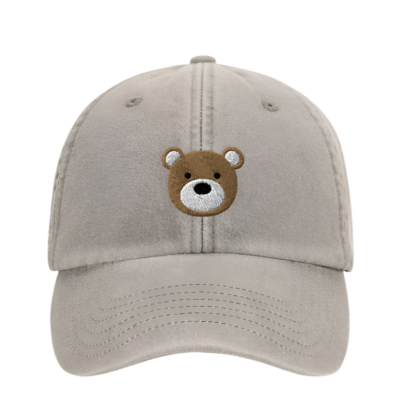 Beige cap with a bear face emblem on a white background